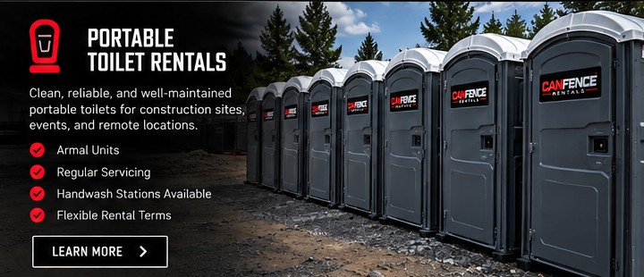 Grey portable toilets with white roofs on a work site